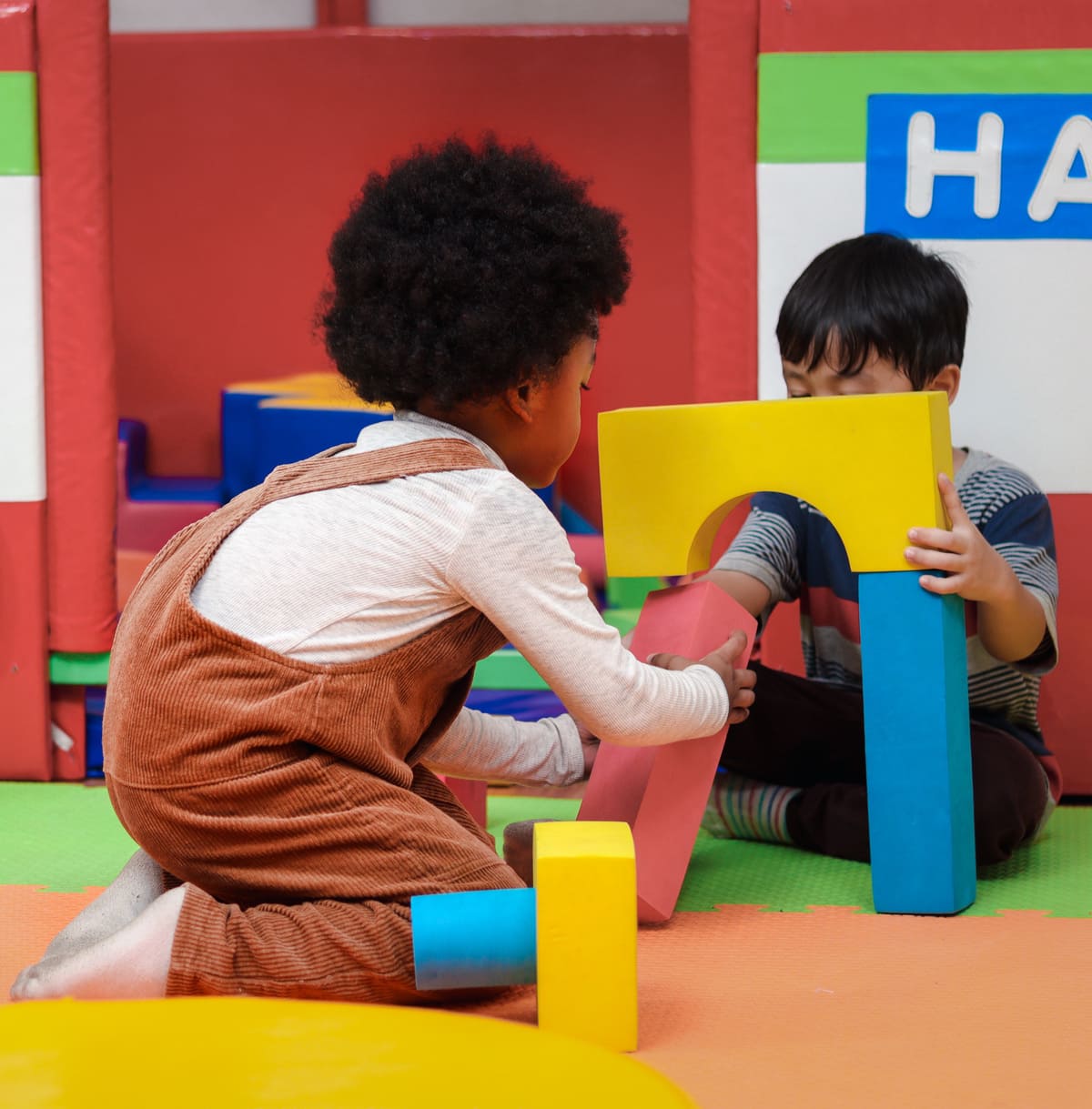 Two children playing with multi colored blocks